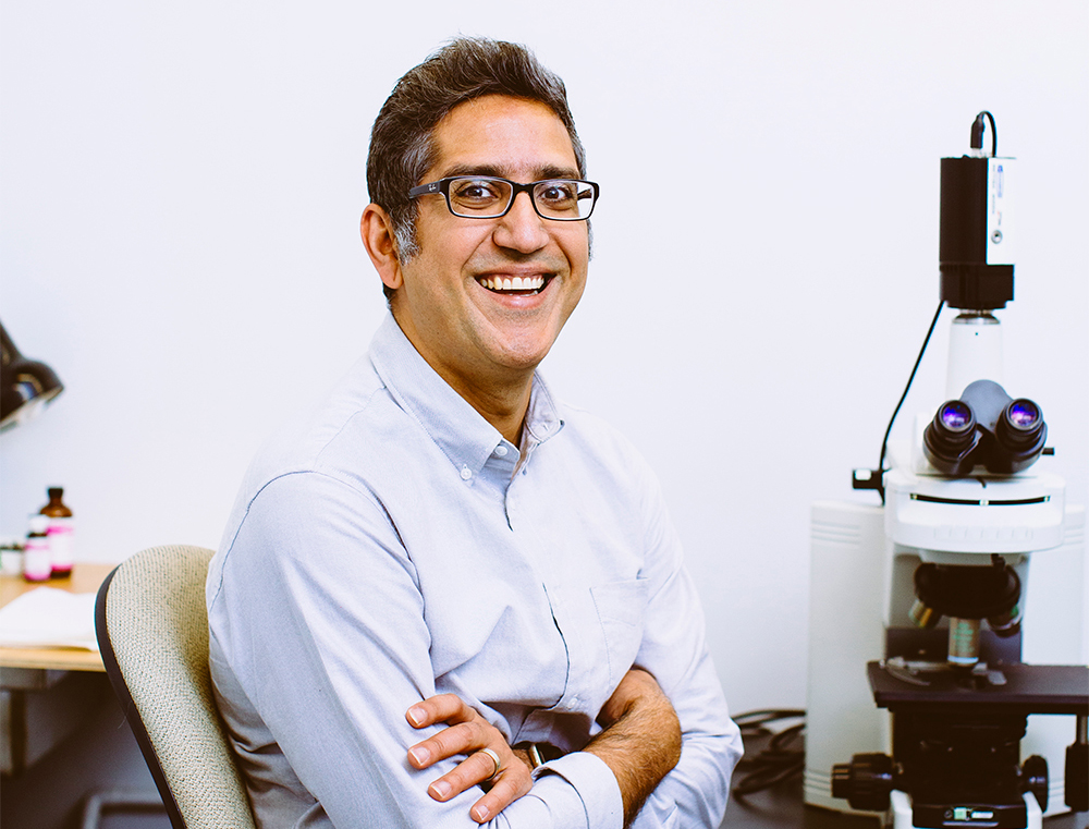 Arash Komeili next to a microscope