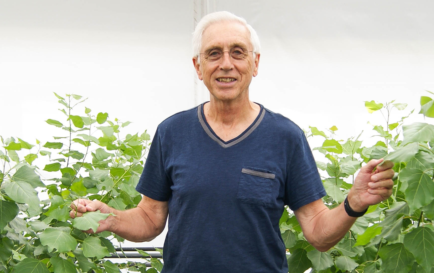 Norman Terry, smiling and holding plants