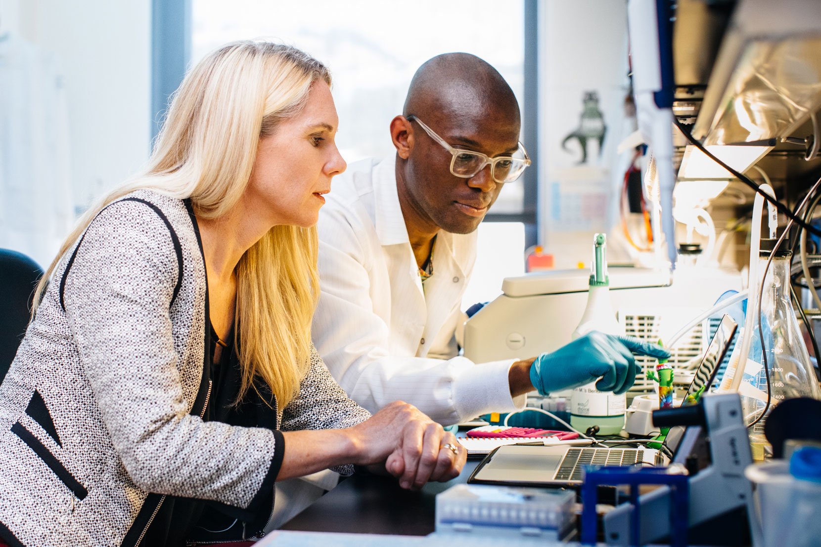 Two scientists looking at a computer in a lab