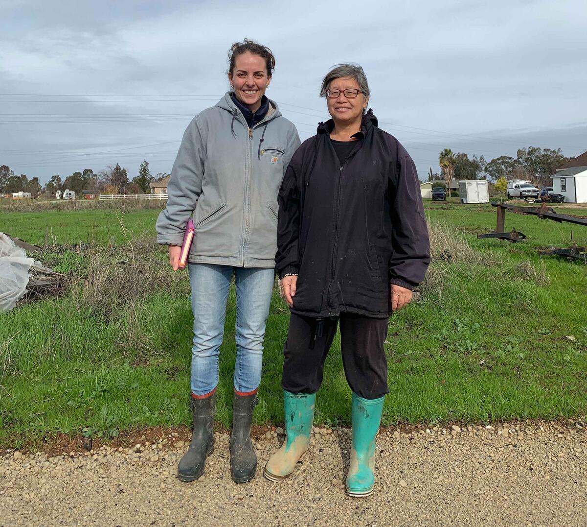 Two people standing outside with wader boots on