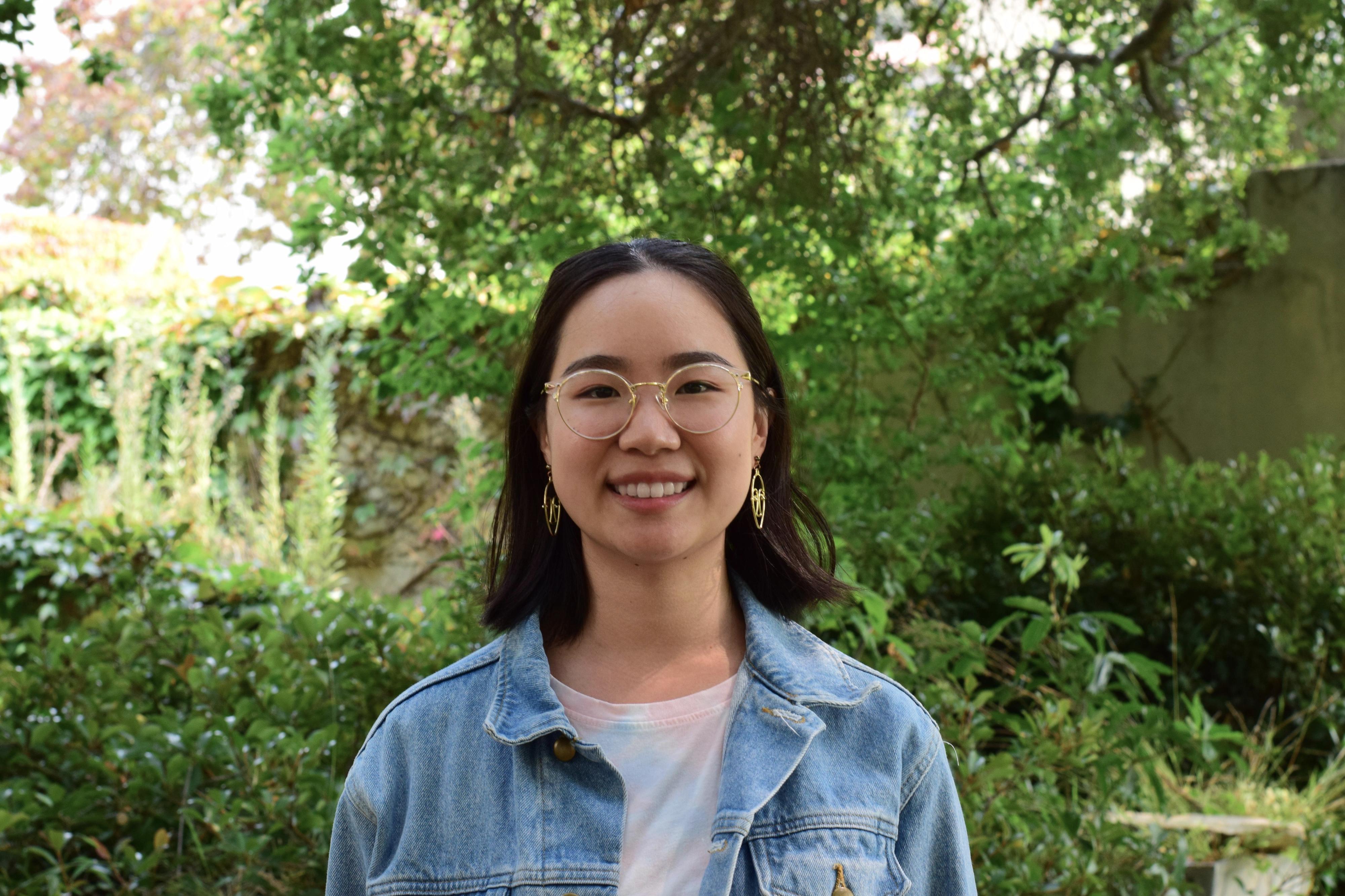 A photo of Eleanor Wang, a femme-presenting Asian American with glasses and short black hair